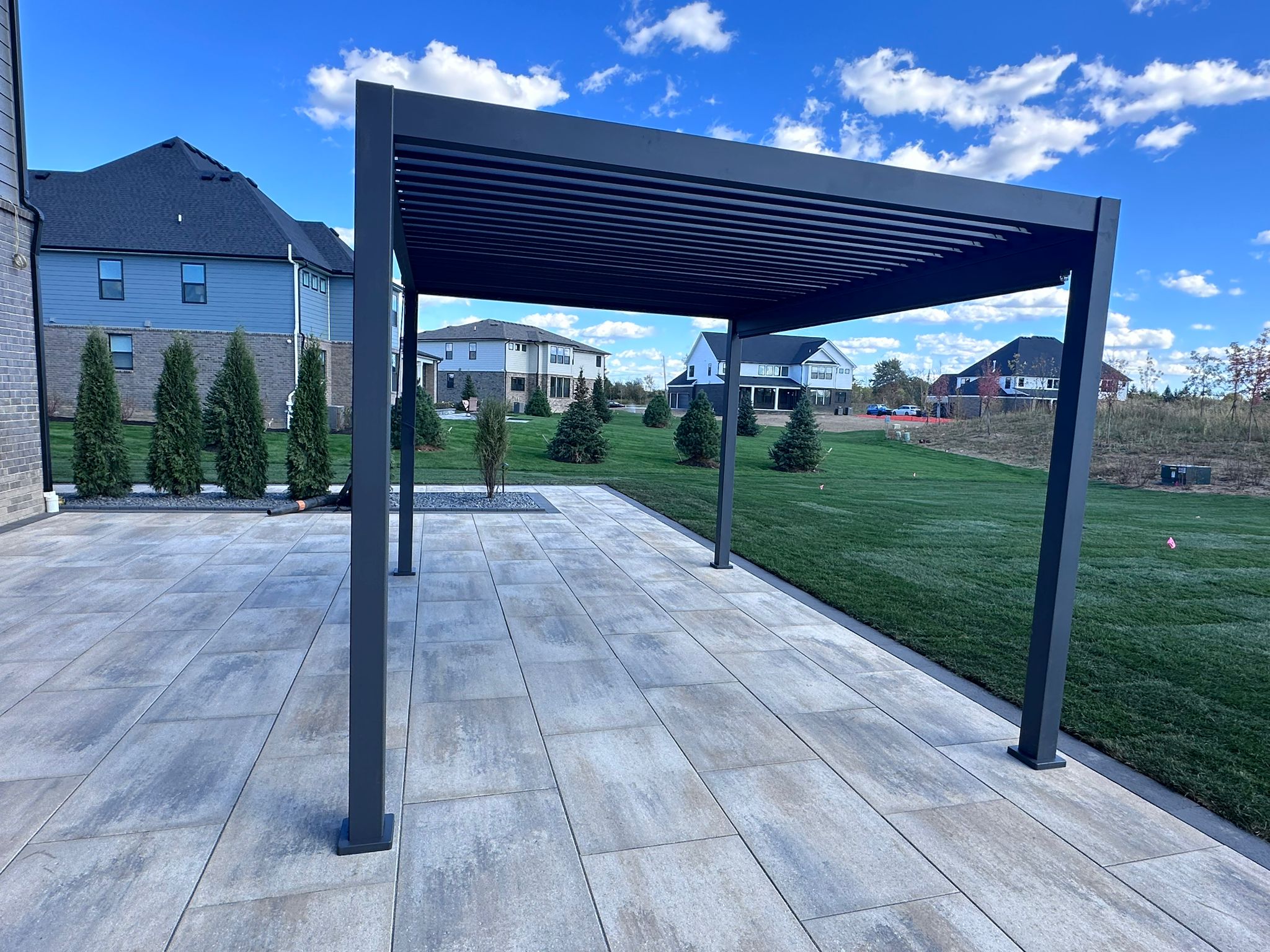 Modern black pergola on concrete patio